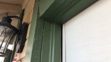 Close view of the white Amarr garage door fitted against green trim