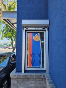 Clear anodized counter shutter installed over a Dutch Bros service window in Stockton