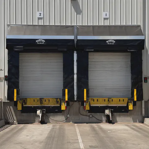 Two black dock shelters with rain diverters installed at loading bays in Ballico