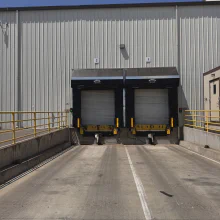 Wide view of the two completed loading-bay shelters and approach in Ballico