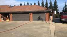 Earlier dark short raised-panel garage doors on the same Lodi brick garage