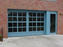 Blue custom full-view sectional door with matching glass entry door