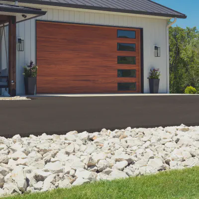 Cedar-tone CHI Skyline Flush garage door with vertically stacked windows on a modern white home