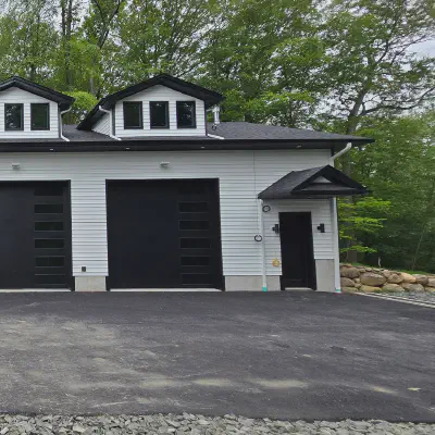 Four black CHI Skyline Flush garage doors with stacked windows on a white multi-bay garage