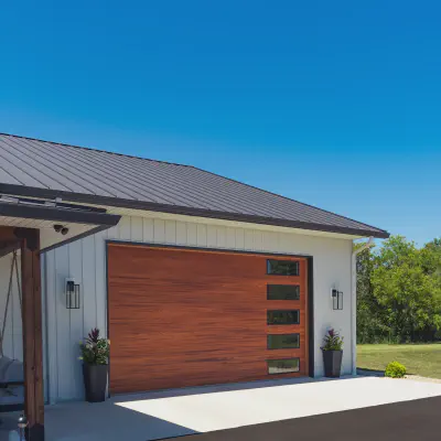 Cedar-tone CHI Skyline Flush garage door with vertically stacked windows on a modern stucco home