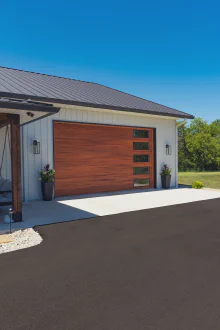 Cedar-tone CHI Skyline Flush garage door with vertically stacked windows on a modern stucco home