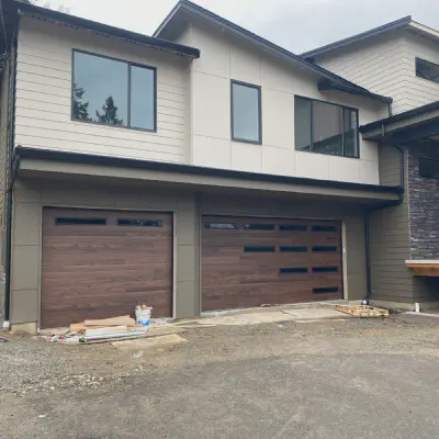 Dark oak CHI Skyline Flush garage doors with offset StyleLite windows on a contemporary home