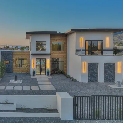 Black-framed CHI full-view glass garage doors on a contemporary home at dusk