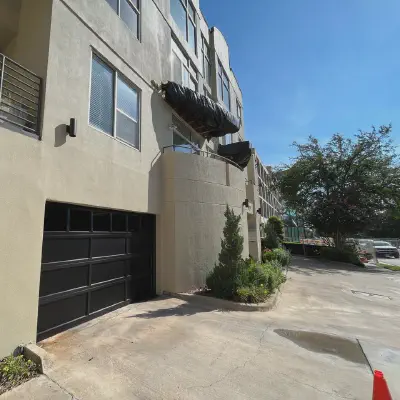 Black CHI full-view glass garage door on a modern urban residence