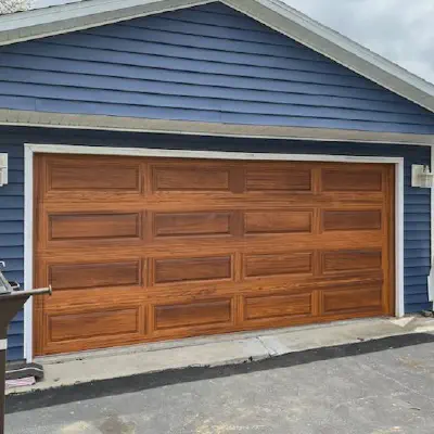 Cedar-tone CHI long raised-panel garage door on a blue home