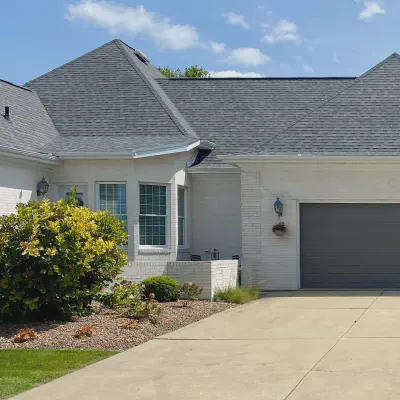 Graphite CHI short raised-panel garage doors on a white brick home