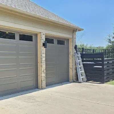 Sandstone CHI long raised-panel garage door with top-row windows on a brick home
