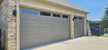 Sandstone CHI long raised-panel garage door with top-row windows on a brick home