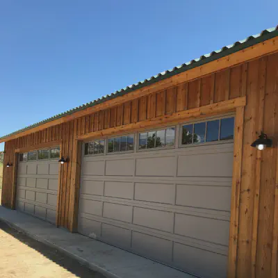 Sandstone CHI recessed long-panel garage door with Madison windows on a wood-sided garage