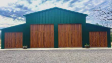 Cedar-tone CHI Shoreline overlay doors with vertical windows on a green barn