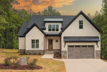 Driftwood CHI Stamped Carriage House garage door with windows on a modern farmhouse