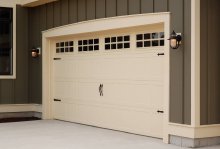Cream C.H.I. stamped carriage house garage door with square windows and black strap hinges