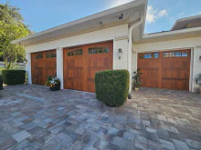 Cedar-tone CHI Stamped Shaker garage doors with top-row windows on a stucco home