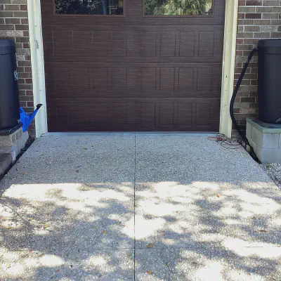 Dark CHI Stamped Shaker garage door with top-row windows on a brick garage