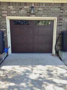 Dark CHI Stamped Shaker garage door with top-row windows on a brick garage