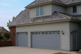 Charcoal gray raised-panel garage door with windows
